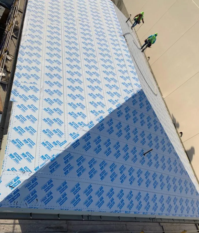 Professional roofers installing underlayment on a metal roof in Monessen